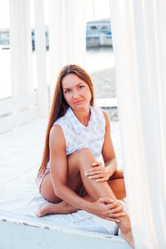 tanned woman with long hair sits