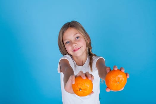 Beautiful girl holding a ripe orange