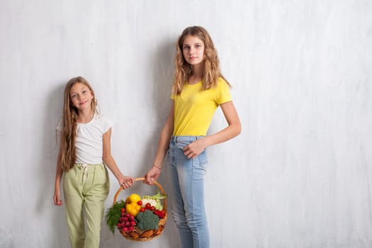 boy and girls with a basket of ripe vegetables and fruits