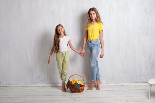 boy and girls with a basket of ripe vegetables and fruits