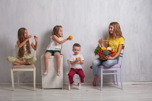 boy and girls with a basket of ripe vegetables and fruits