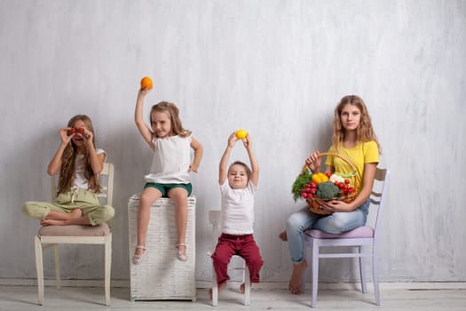 boy and girls with a basket of ripe vegetables and fruits