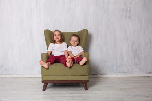 Boy and girl sit in green chair