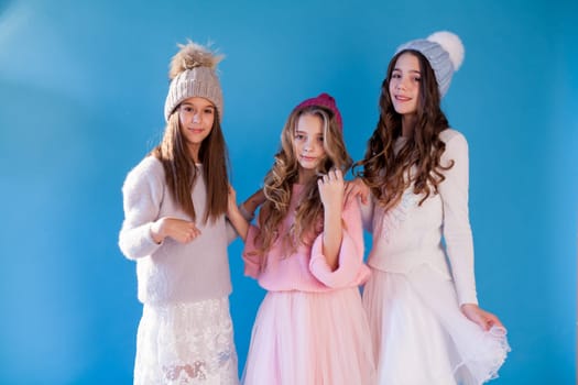 portrait of three beautiful little girls in a winter hat