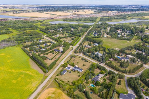 Experience the charm of Cedar Villa Estates from above. This drone image beautifully showcases the area's spacious estates, lush greenery, and tranquil setting, offering a unique aerial perspective of Saskatoon.