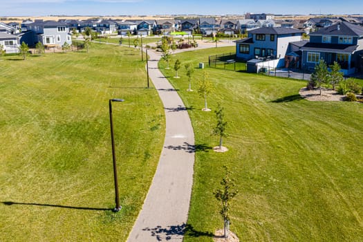 Experience the vibrant Brighton neighborhood in Saskatoon from the sky. This drone-captured image reveals the area's dynamic blend of modern living, lush parks, and community spirit, all from a stunning aerial viewpoint.