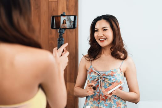 Woman influencer shoot live streaming vlog video review makeup uttermost social media or blog. Happy young girl with cosmetics studio lighting for marketing recording session broadcasting online.