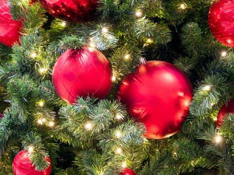Red bauble with golden ornament on pine tree brench. Closeup look of Christmas decorations