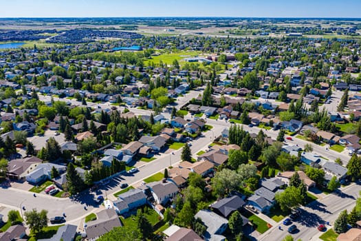 Experience the serene beauty of Lakeridge in Saskatoon from above. This drone image showcases the neighborhood's tranquil streets, lush green spaces, and the harmonious blend of urban and nature.