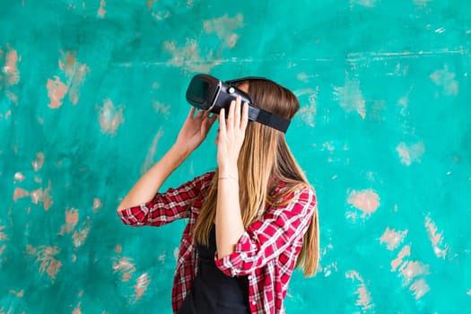 Young woman with pleasure uses head-mounted display.