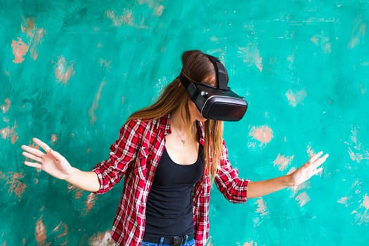 Young woman getting experience using VR-headset glasses of virtual reality much gesticulating hands.