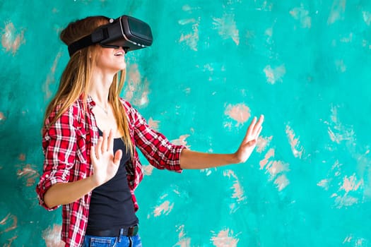 Young woman getting experience using VR-headset glasses of virtual reality much gesticulating hands.