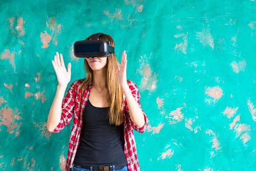 Young woman getting experience using VR-headset glasses of virtual reality much gesticulating hands.