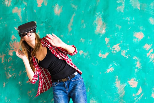 Young woman getting experience using VR-headset glasses of virtual reality much gesticulating hands.