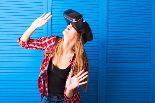 Young woman getting experience using VR-headset glasses of virtual reality much gesticulating hands.