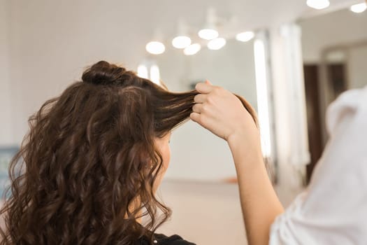 Closeup woman hairdresser coiffeur makes new hairstyle.