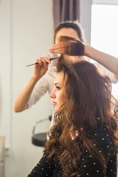 Closeup woman hairdresser coiffeur makes new hairstyle.