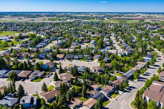 Experience the serene beauty of Lakeridge in Saskatoon from above. This drone image showcases the neighborhood's tranquil streets, lush green spaces, and the harmonious blend of urban and nature.