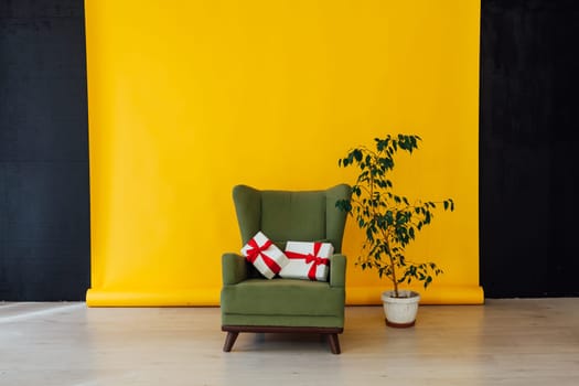 vintage armchair and home plant with a gift in the interior of the room with a yellow background