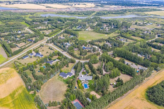 Experience the charm of Cedar Villa Estates from above. This drone image beautifully showcases the area's spacious estates, lush greenery, and tranquil setting, offering a unique aerial perspective of Saskatoon.