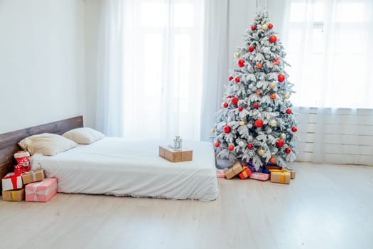 Christmas tree in the bedroom with bed and gifts holiday new year winter