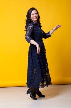 portrait of a beautiful woman in a blue dress against a yellow background