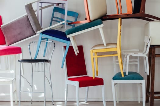 many multicolored chairs in the mess of the white room moving