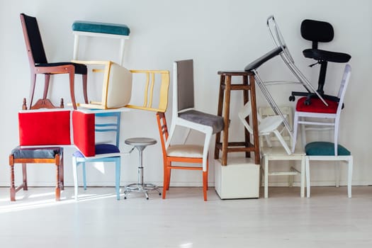 many multicolored chairs in the mess of the white room moving