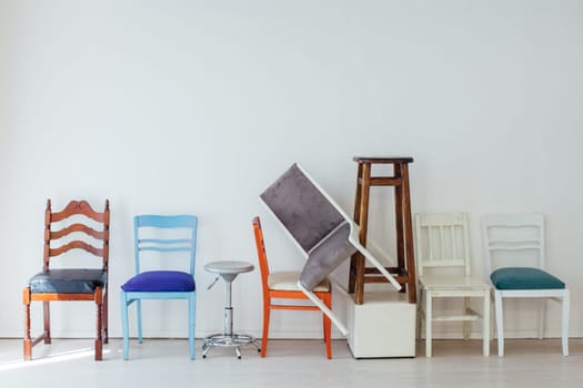 many multicolored chairs in the mess of the white room moving