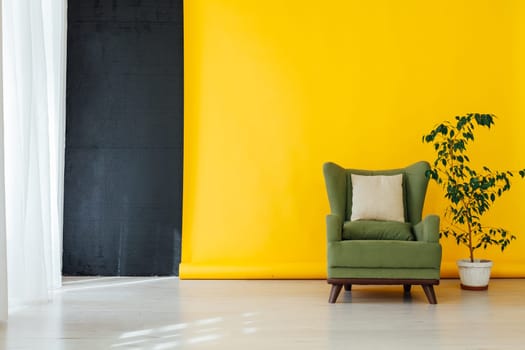 green chair with a home plant in the interior of the room with a yellow background