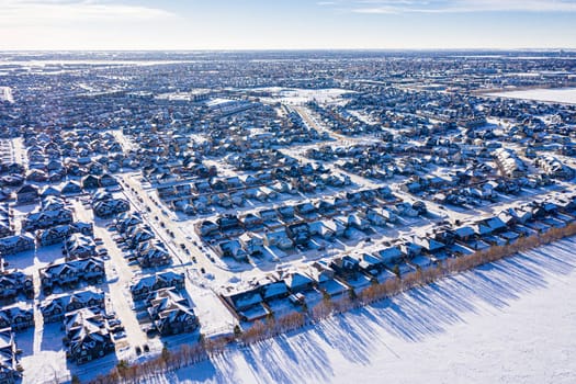 Aerial image of Willowgrove, Saskatoon, SK, showcasing its modern homes, intricate pathways, and lush parks. A neighborhood echoing family-centric living. Ideal for urban planning and real estate.