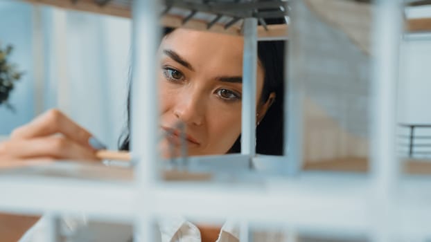 Closeup of young beautiful caucasian skilled architect engineer focusing on checking the house model structure with confident. Creative and professional design concept. Portrait. Immaculate.