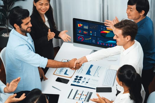 Diverse group of office employee worker shake hand after making agreement on strategic business marketing meeting. Teamwork and positive attitude create productive and supportive workplace. Prudent