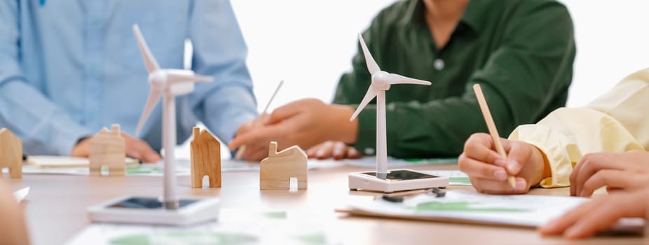 Green business meeting represented renewable energy. Skilled businesspeople discuss green business investment at table with environmental documents. Closeup. Focus on hand. Delineation.