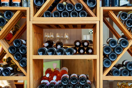 A luxurious wine display featuring a wooden rack overflowing with premium expensive wines, adding elegance and sophistication to any wine-related promotion.
