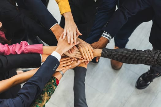 A group of diversity people putting their hands together. Showing unity teamwork and friendship. Close up top view of young business man and business woman joining as a team. Intellectual.