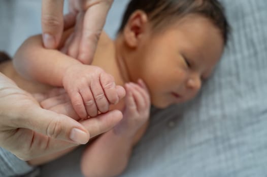 A newborn boy holds his mother's finger. Close-up of hands