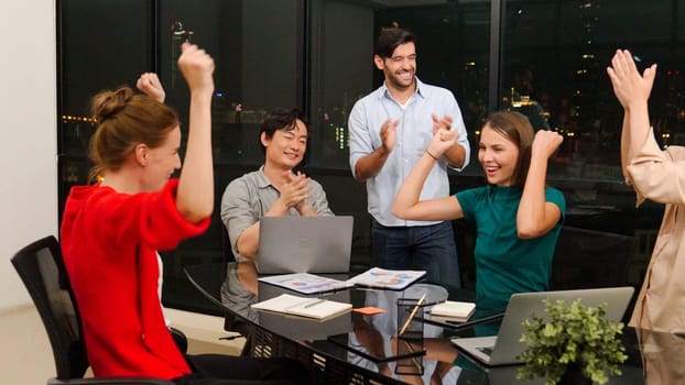 Businesspeople putting hands together and clapping hands to celebrate successful project at modern office with night city view. Group of manager with stacks of hands. Teamwork, trust. Tracery