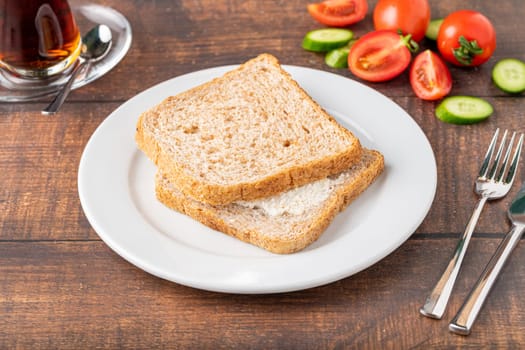 Cream cheese sandwich on white porcelain plate on wooden table