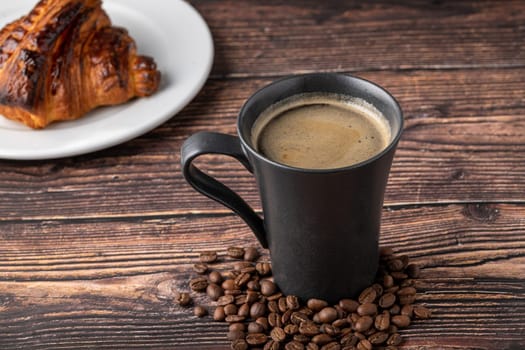 Relaxing americano coffee in black porcelain cup on wooden table