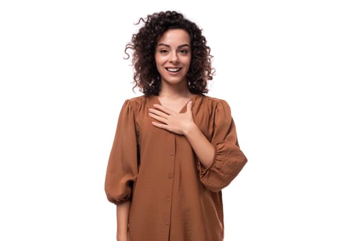 young fashionista curly brunette woman dressed in a stylish brown blouse.