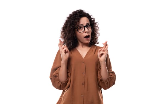 young confident pretty caucasian office worker woman with curly black hair in brown blouse.