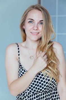 Portrait of beautiful blonde woman in light summer dress