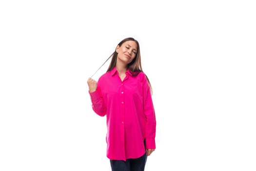 portrait of a dreamy young lady with black hair in a crimson oversized shirt on a studio white background.