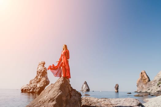 Woman travel sea. Happy tourist taking picture outdoors for memories. Woman traveler looks at the edge of the cliff on the sea bay of mountains, sharing travel adventure journey.