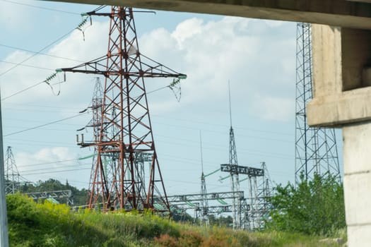 High voltage towers with sky background. Power line support with wires for electricity transmission. High voltage grid tower with wire cable at distribution station. Energy industry, energy saving.