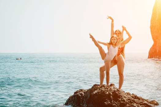 Silhouette mother and daughter doing yoga at beach. Woman on yoga mat in beach meditation, mental health training or mind wellness by ocean, sea