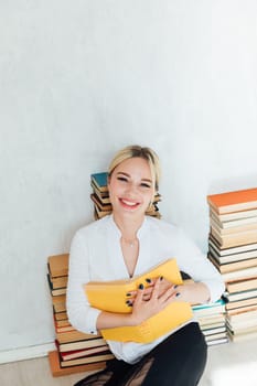 Beautiful smart woman sitting on books loves to read