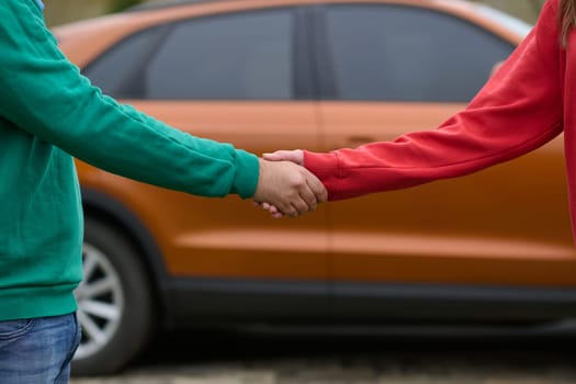 Car keys handshake, seller or car salesman and customer in a dealership, shake hands over the car keys and seal the purchase of the auto or new car.