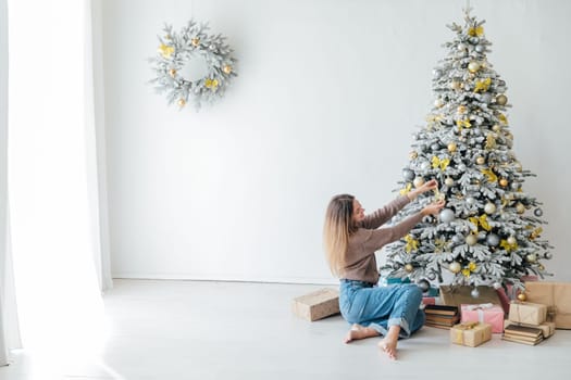 Woman decorating christmas tree gifts